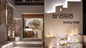 Der Eingang eines Luxushotels mit einer Steinsäule, einer Holztür und einem Schild mit der Aufschrift "analéa luxury hotel".