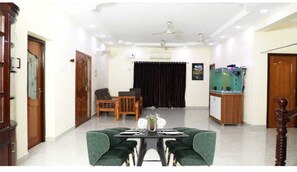 Enjoy meals with family and friends in this room's dining area, featuring a table and four comfortable chairs.