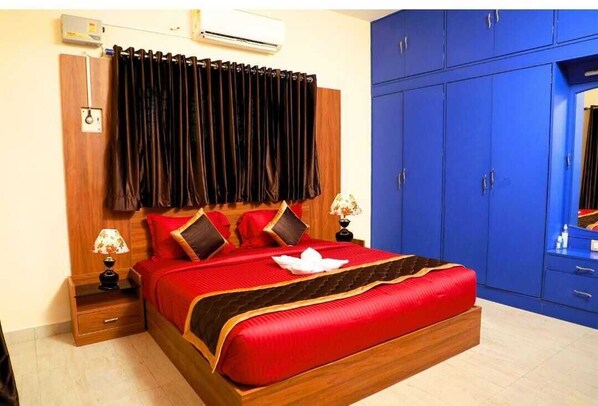 Relax in a spacious room with a large bed, nightstand, and wardrobe.