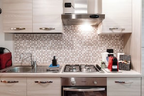 Dúplex, balcón | Cocina privada | Refrigerador, microondas, horno y parrilla de estufa 