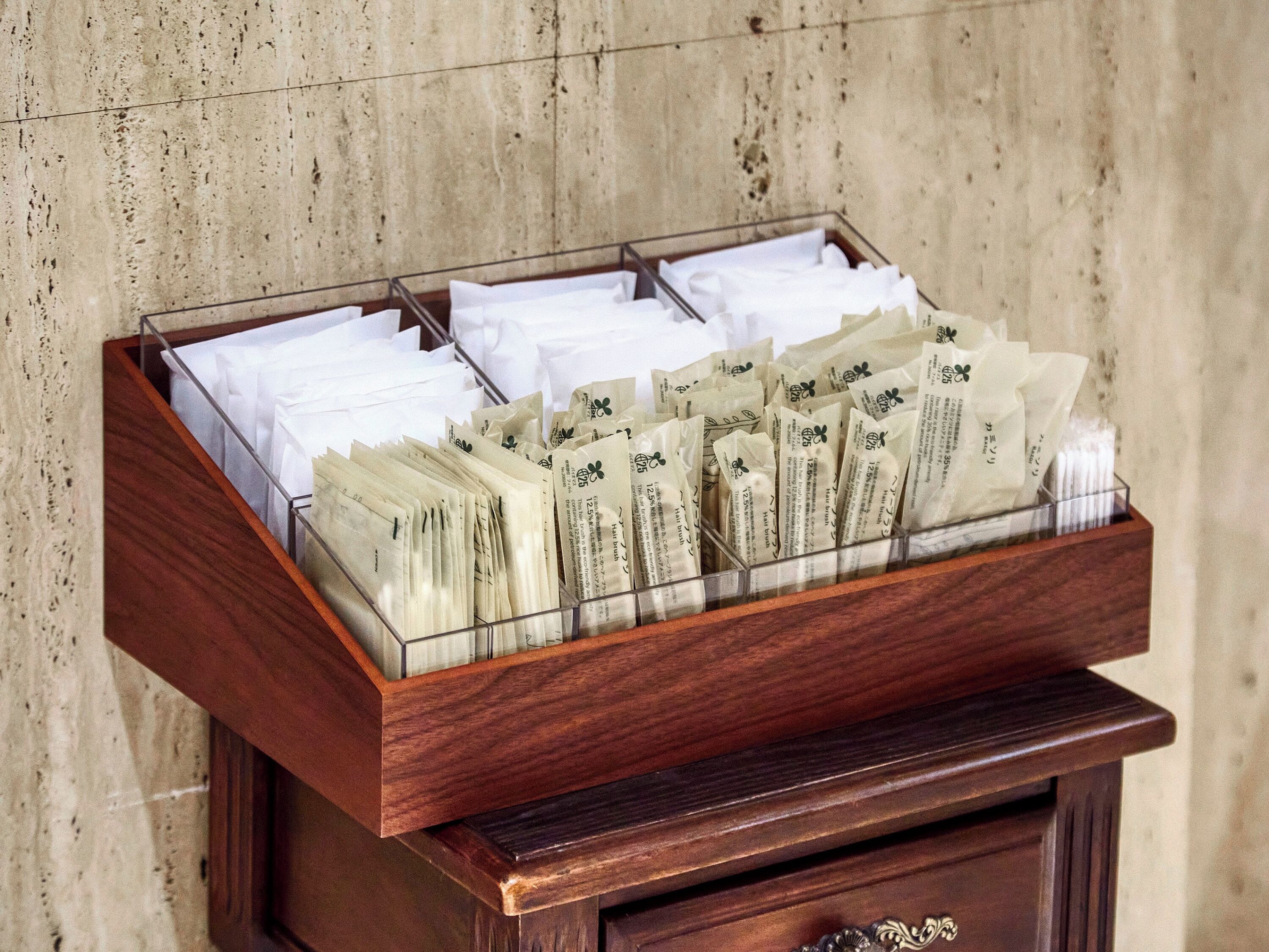 A wooden box filled with neatly arranged envelopes, likely containing information or promotional materials.