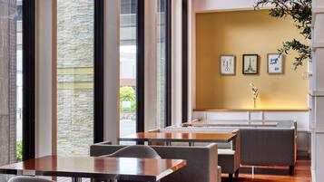 A modern interior with large windows, stone walls, and a wooden floor.