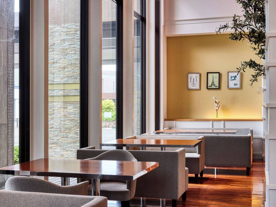 A modern interior with large windows, stone walls, and a wooden floor.