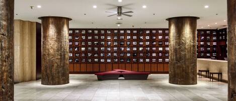 A lobby with a central seating area, a ceiling fan, and a wall of framed pictures.