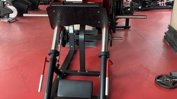 A gym with exercise equipment, including a bench press and weight machines.