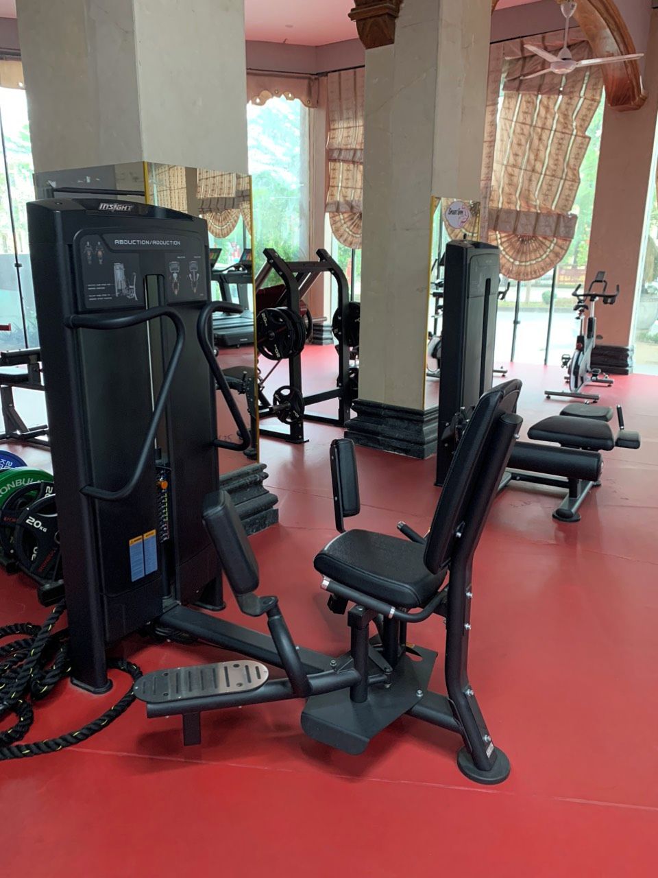 A gym with exercise equipment, including a leg press machine and a bench press.