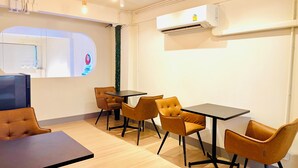Une salle de conférence moderne, dotée d’une grande table, de quatre chaises et d’un climatiseur fixé au mur.