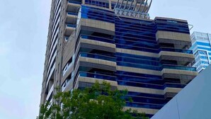 Un edificio alto y moderno con varios pisos, ventanas amplias y un llamativo esquema de color azul y blanco.