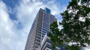 Un edificio alto y moderno con varios balcones y un cielo despejado.