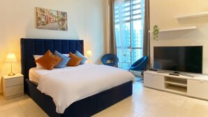 Un dormitorio moderno con una cama grande, televisión y vistas a la ciudad.