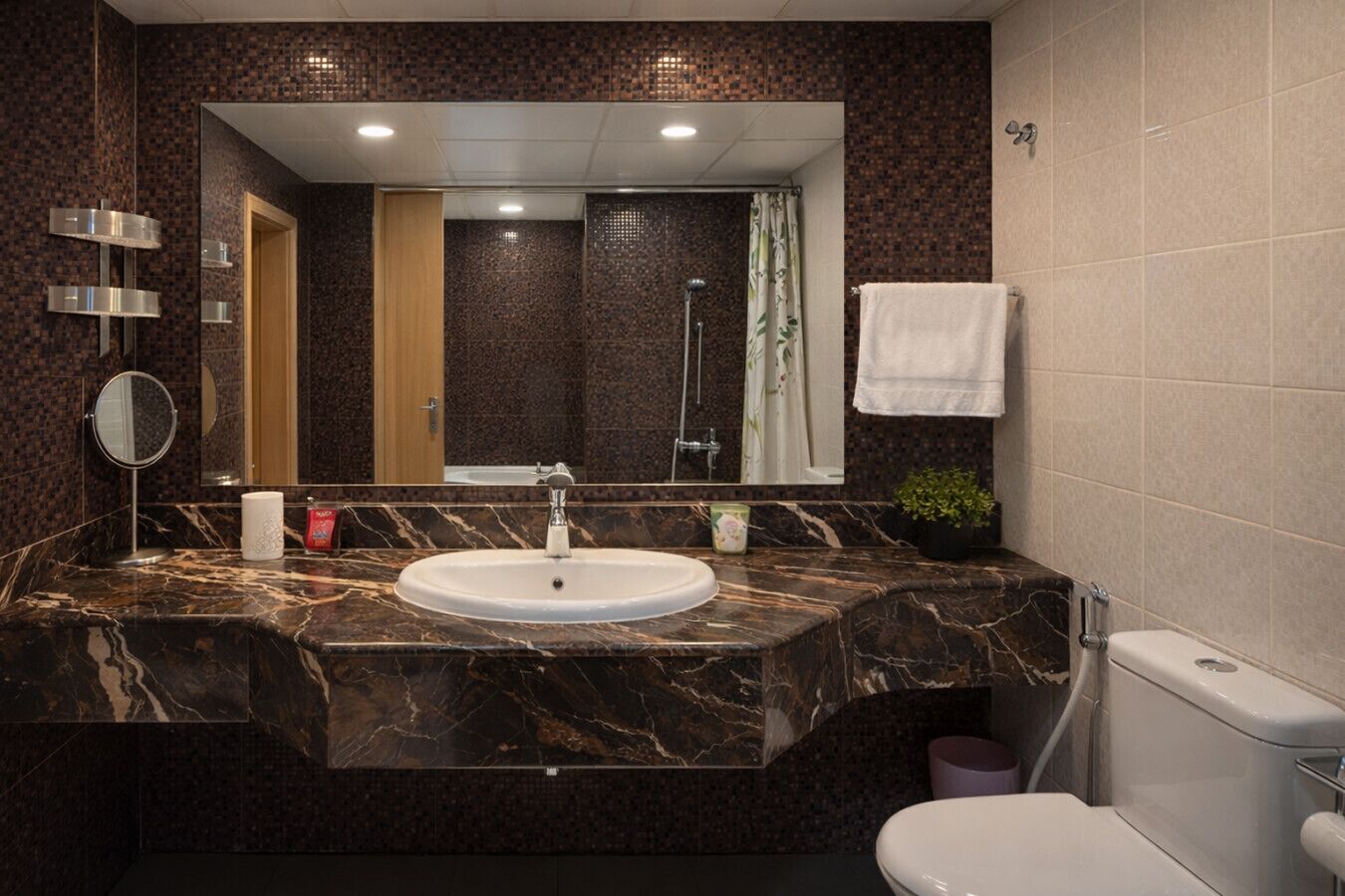 Une salle de bain avec un lavabo en marbre, un miroir, des toilettes et une douche.