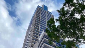 Un immeuble moderne et imposant, doté de nombreux balcons et de grandes fenêtres.