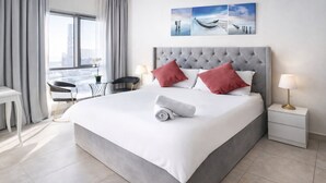 Une chambre d’hôtel moderne avec un grand lit, une vue sur la ville, un bureau et une chaise.