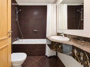Ein Badezimmer mit Toilette, einer Badewanne und einem Waschbecken.