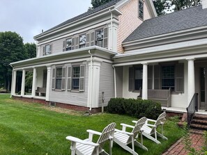 A two-story house with a porch and a covered front entrance. - Remodeled historic Captains home w/fireplaces, large yard, 5 mins walk to beach  (Yarmouth)