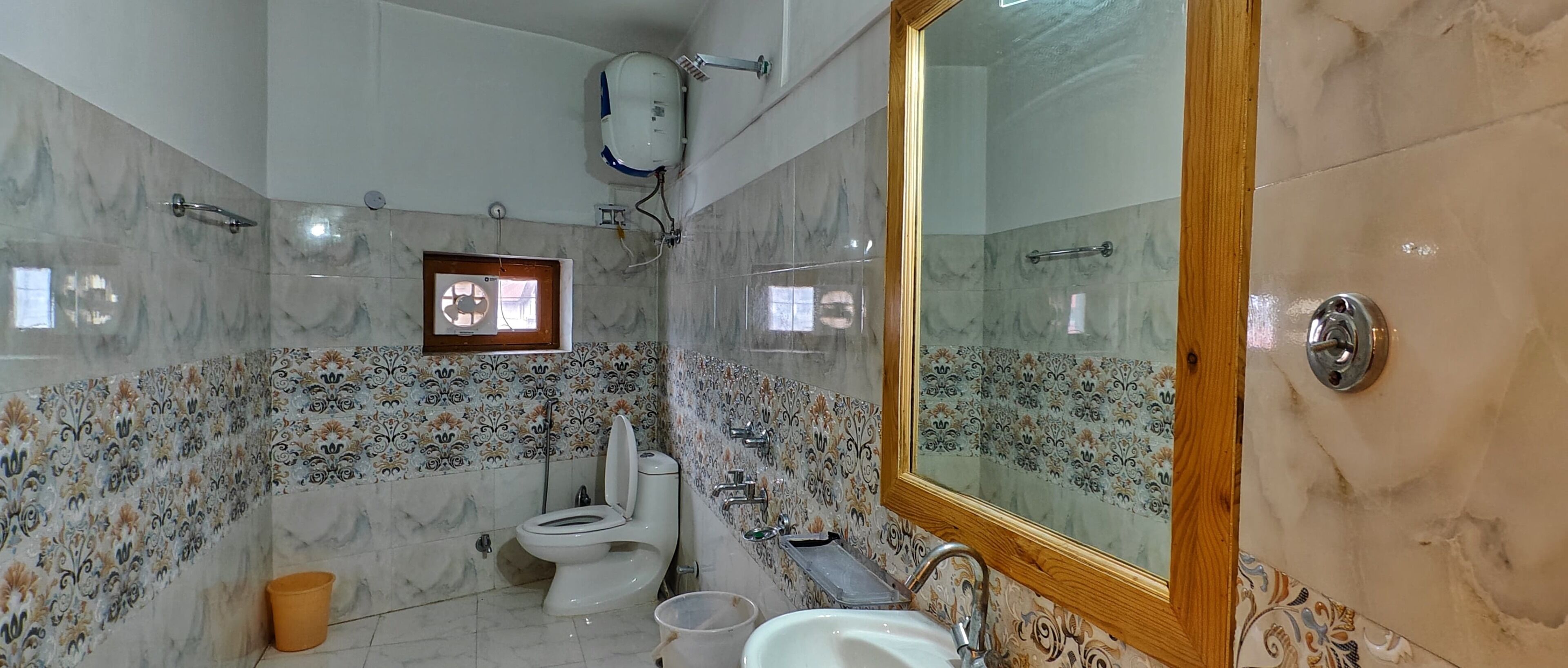 A bathroom with a toilet, sink, and mirror.