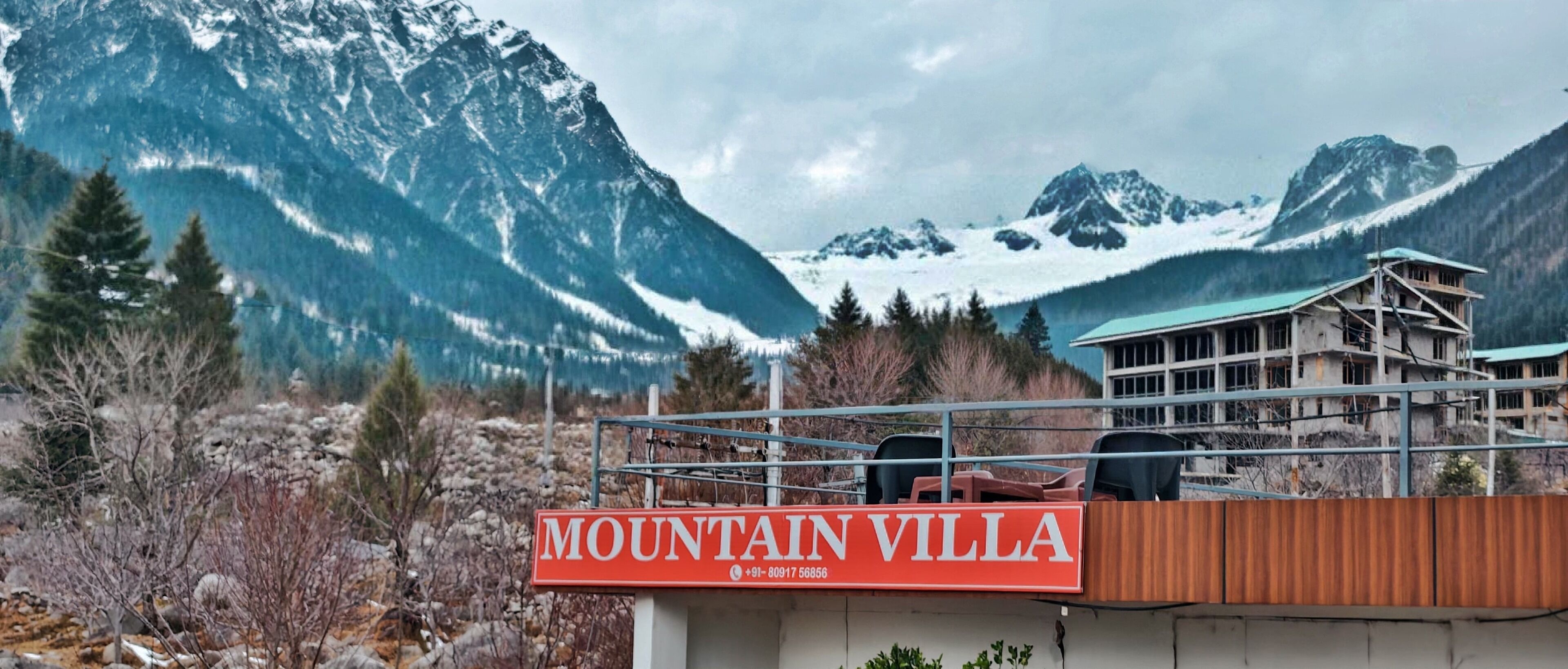 A sign for "MOUNTAIN VILLA" with a mountainous backdrop.