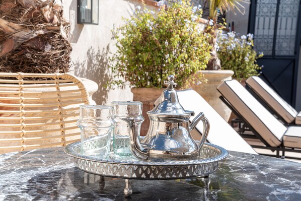 A tray with a silver teapot, glasses, and a sugar bowl on a marble table. - Riad COPAH (Marrakech)