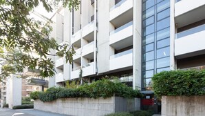 A modern multi-story building with balconies, concrete barriers, and greenery. - GuestHost - Modern apartment with balcony in Portello district (Milano)