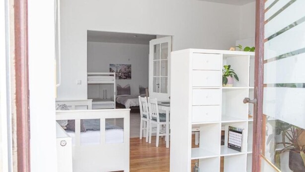 Ein Zimmer mit einem Bett, einem Schreibtisch, einem Stuhl und einem Bücherregal.