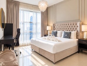 A hotel room with a large bed, a desk, a chair, and a view of the city.