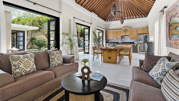 A spacious living area with a high ceiling, a dining area, and a kitchen. - Sombra Villa by Kozystay - Sanur (Denpasar)