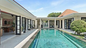 A modern house with a swimming pool, a dining area, and a covered patio. - Sombra Villa by Kozystay - Sanur (Denpasar)