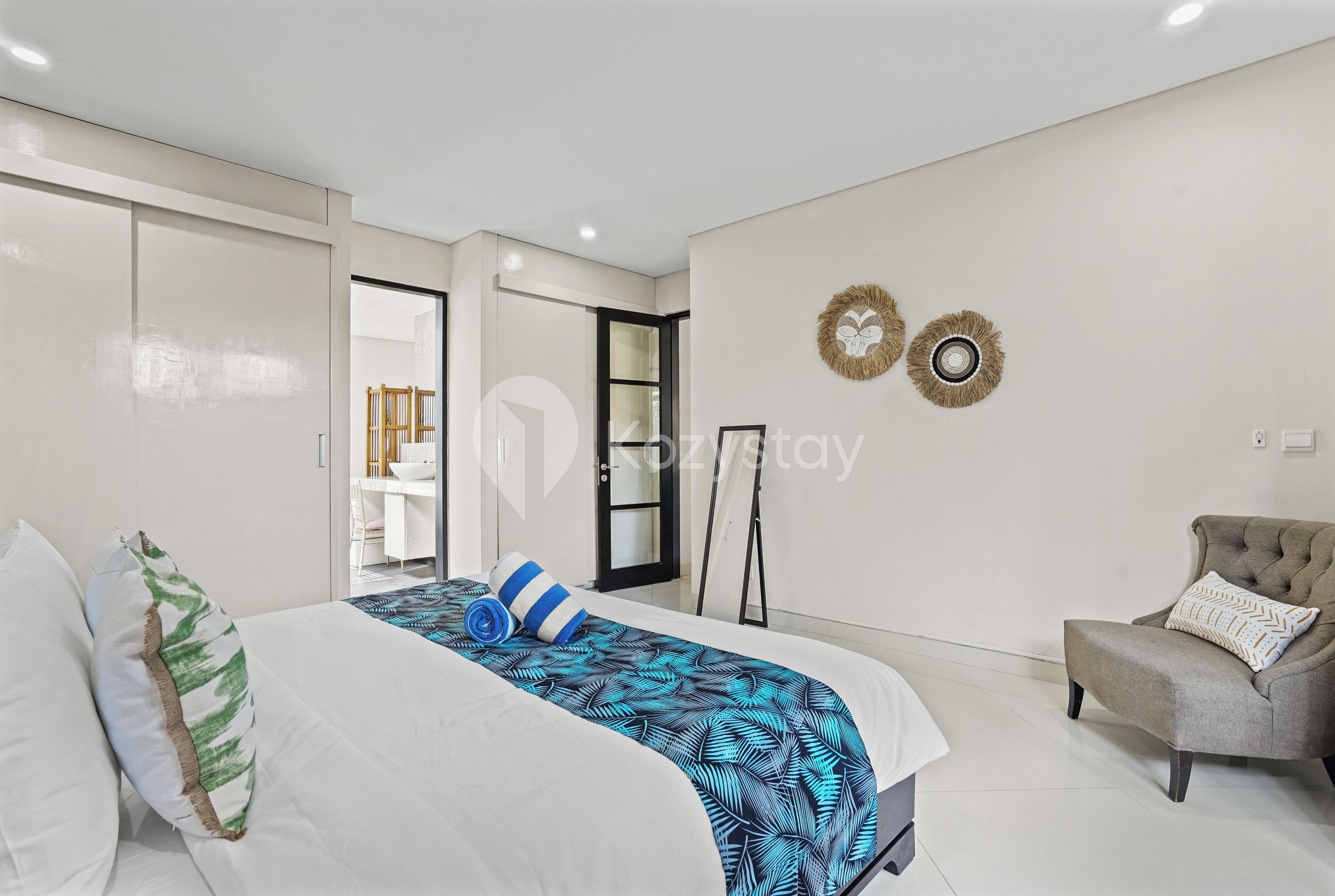 A bedroom with a bed, a chair, and a desk.