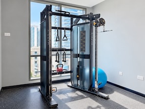 A gym with a squat rack, a bench press, and a kettlebell.