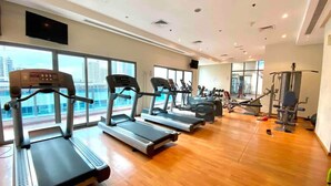 A gym with treadmills, exercise bikes, and weight machines. - Cozy Studio at Marina near Beach & Metro in Marina (Dubai)