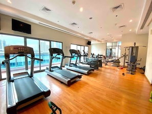 A gym with treadmills, exercise bikes, and weight machines.