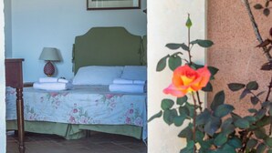 A bedroom with a bed, a nightstand, a lamp, and a framed picture on the wall. - Tenuta San Calogero App Rosmarino (Sicilia)
