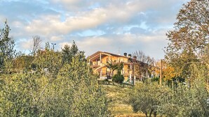 A multi-story house with a balcony, surrounded by olive trees and a grassy area. - Vista Majella by Interhome (Paglieta)