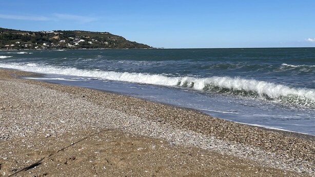 A pebble beach with waves, a clear sky, and a distant hill with buildings. - Vista Majella by Interhome (Paglieta)