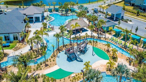 Ein Resort mit großzügigem Poolbereich, Palmen und Blick auf einen See.
