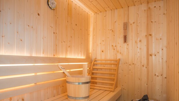 A wooden sauna with benches, a bucket, and a heater. - "Experience unforgettable days in the Dangaster Düne!" (Dangast)