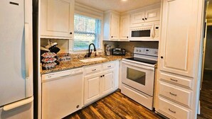 A kitchen with white cabinets, a stainless steel refrigerator, a microwave, a toaster, and a double oven. - 228 Lakeland (Anderson)