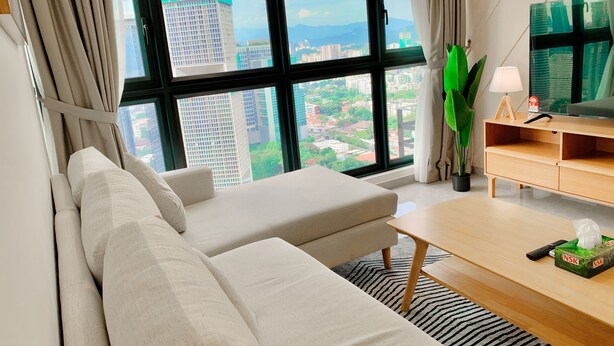 A modern living room with a sofa, a coffee table, and a TV stand. - AGILE Infinity Suites TRX By AR (Kuala Lumpur)