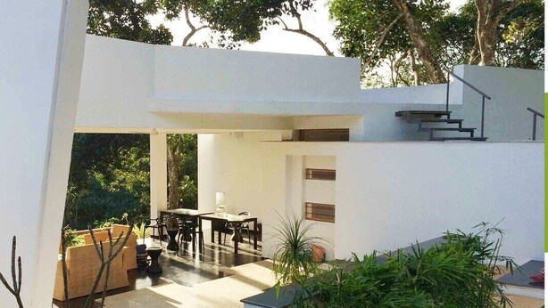 A modern house with a patio area, a dining table, and chairs. - Thapovan  (Kodaikanal)