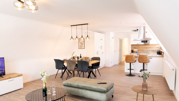 A modern apartment with a dining area, kitchen, and living space. - Apartments am Marktplatz (Bad Urach)