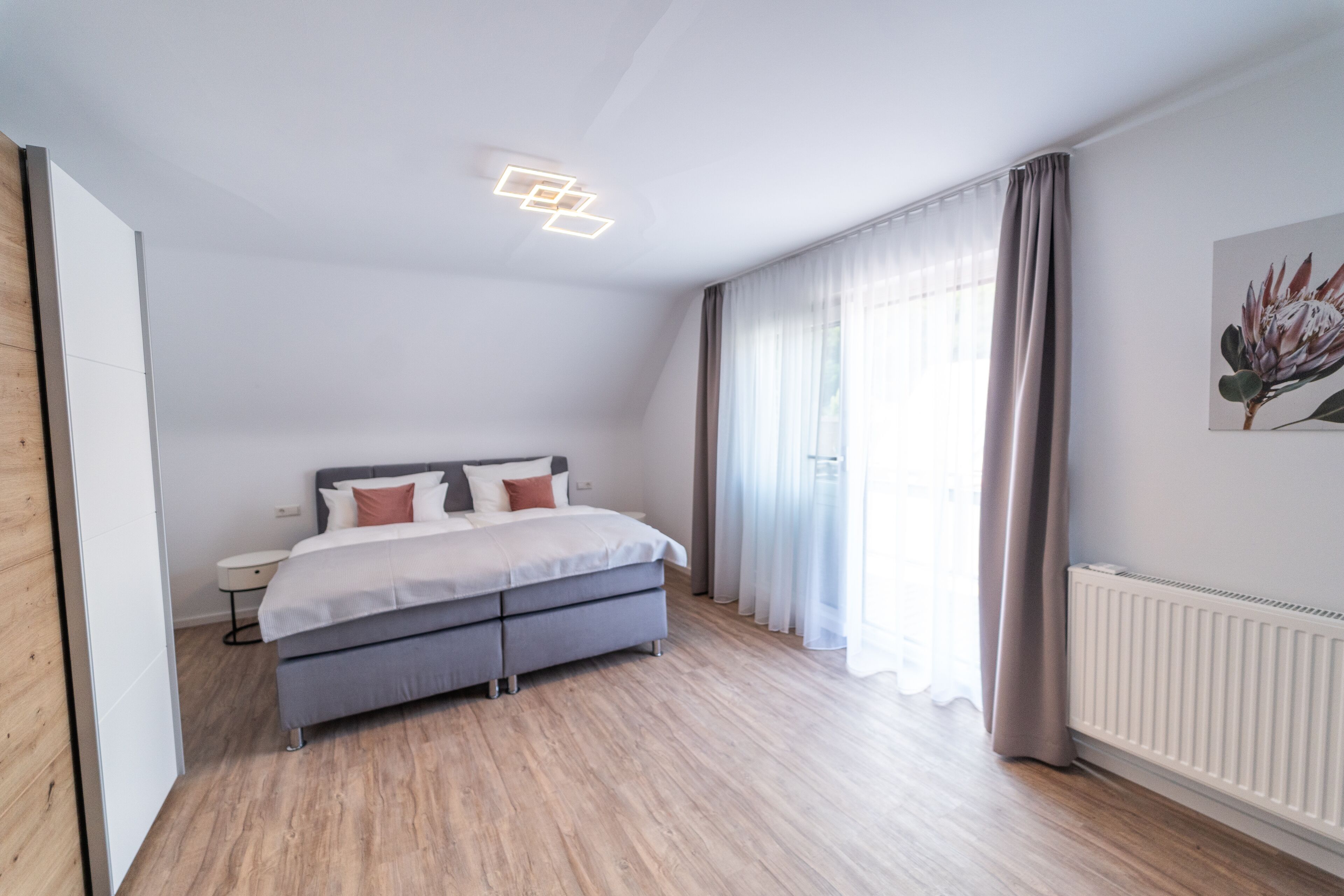 A modern bedroom with a bed, a bedside table, and a radiator.