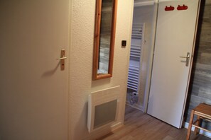 Ein Flur mit einer Tür, einem kleinen Fenster und einer Heizung.