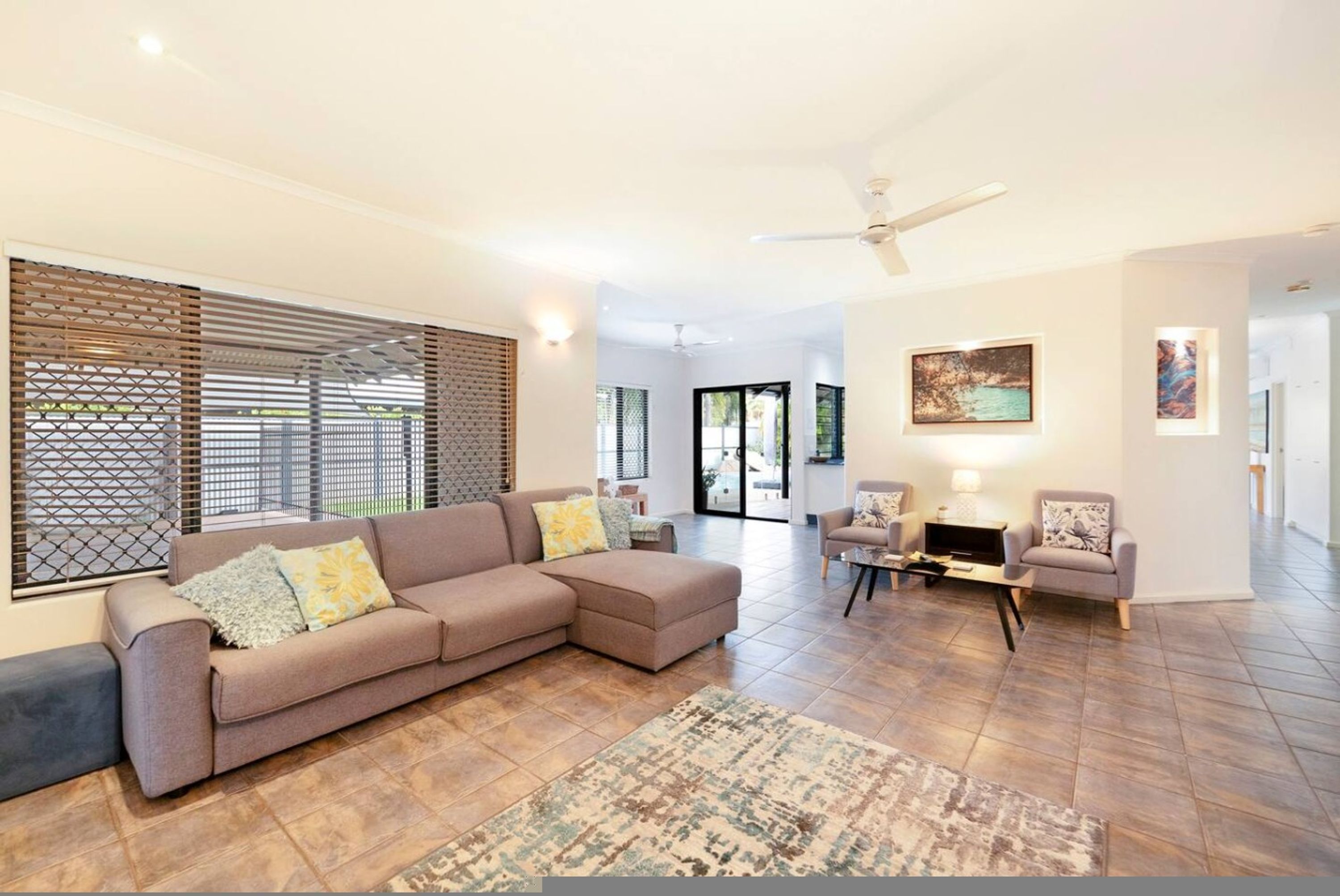 A modern living room with a sectional sofa, a coffee table, and a patterned rug.