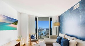 A modern living room with a city view, a large painting, and a map on the wall. - Stylish Beach Apartment with Pool (Hallandale Beach)