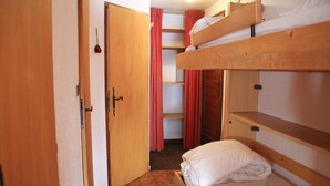 A bunk bed room with a wooden door and a red curtain. - Gelinote Chalet for 4 People (Chatel)