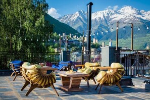 Un espace extérieur aménagé avec des chaises et une table, offrant une vue sur un paysage montagneux.