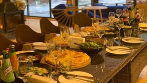 Une salle de restaurant avec une table dressée pour un repas, comprenant des assiettes, des couverts, des verres et une variété de plats.