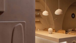 A modern interior with a central island, pendant lighting, and a minimalist design. - Gaia Nest 1-bedroom apartment in Piraeus (Pireas)