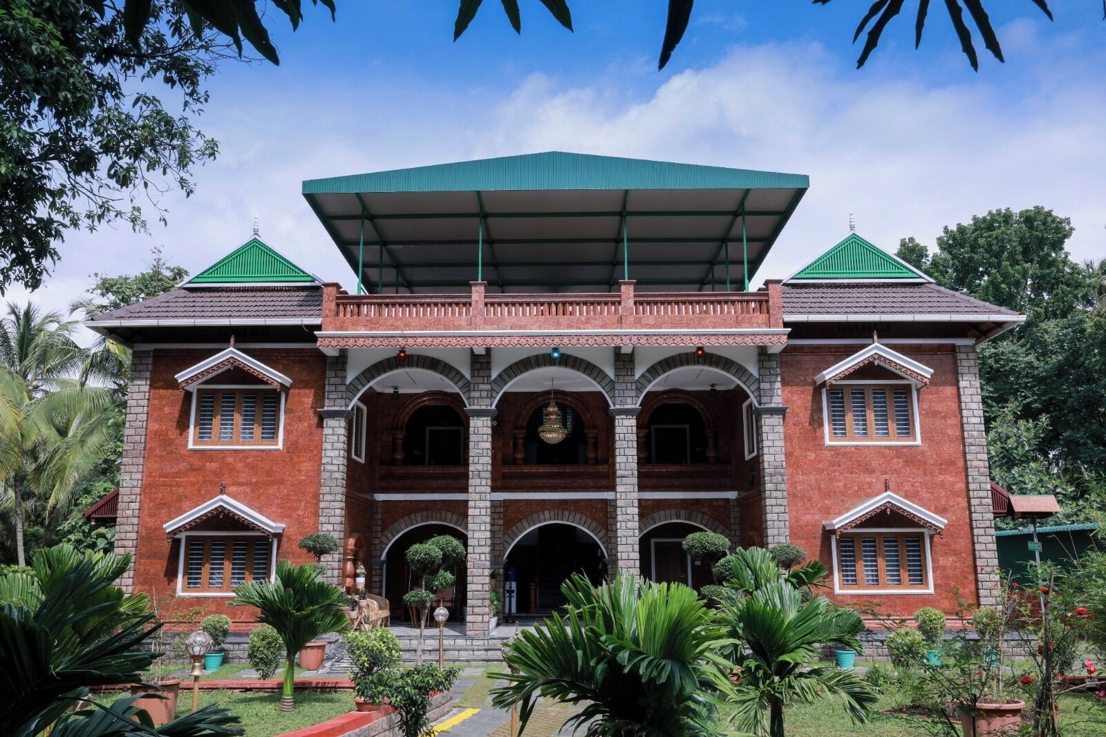 A large, two-story building with a green roof and a central entrance flanked by arched doorways.