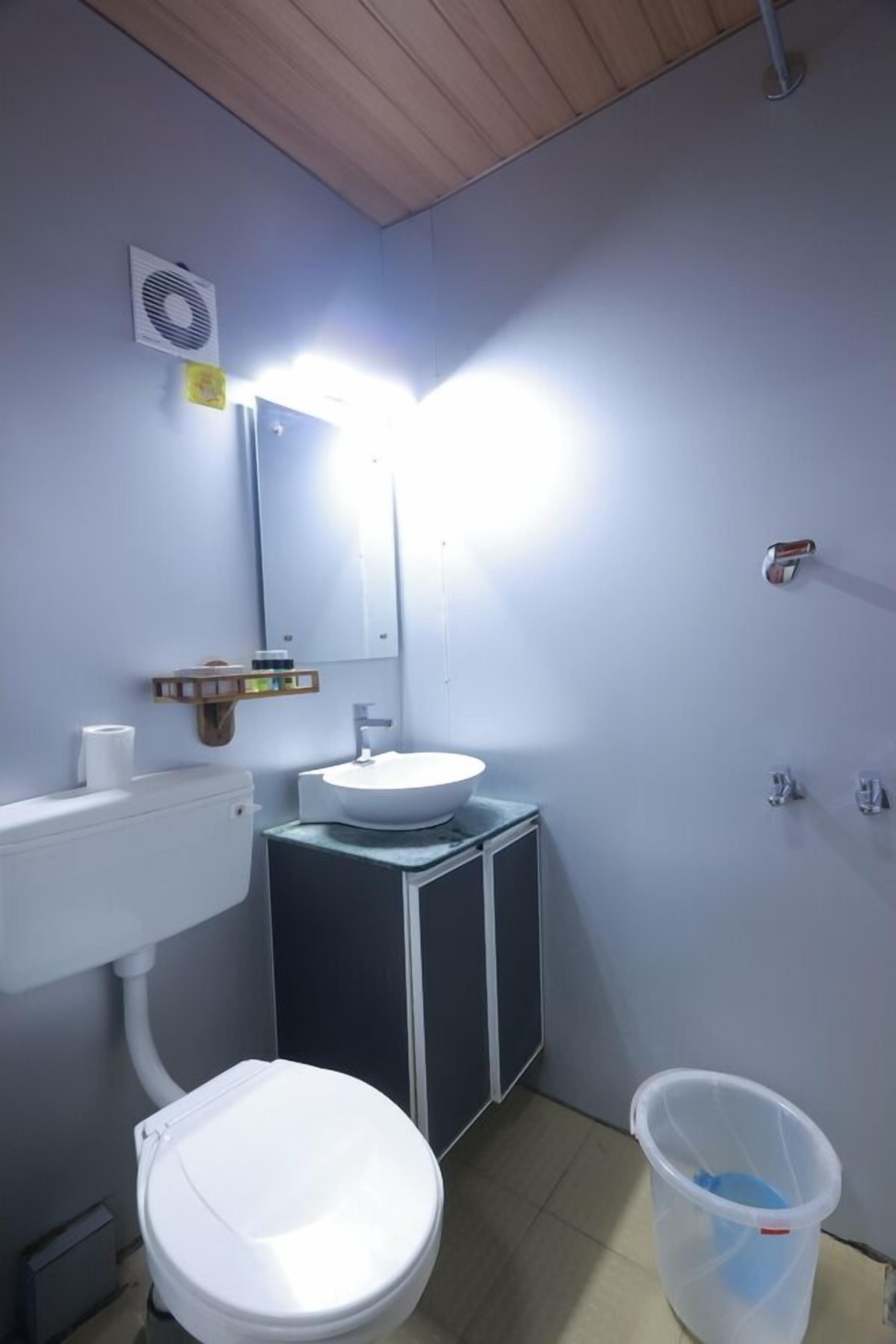 A small bathroom with a toilet, sink, and mirror.